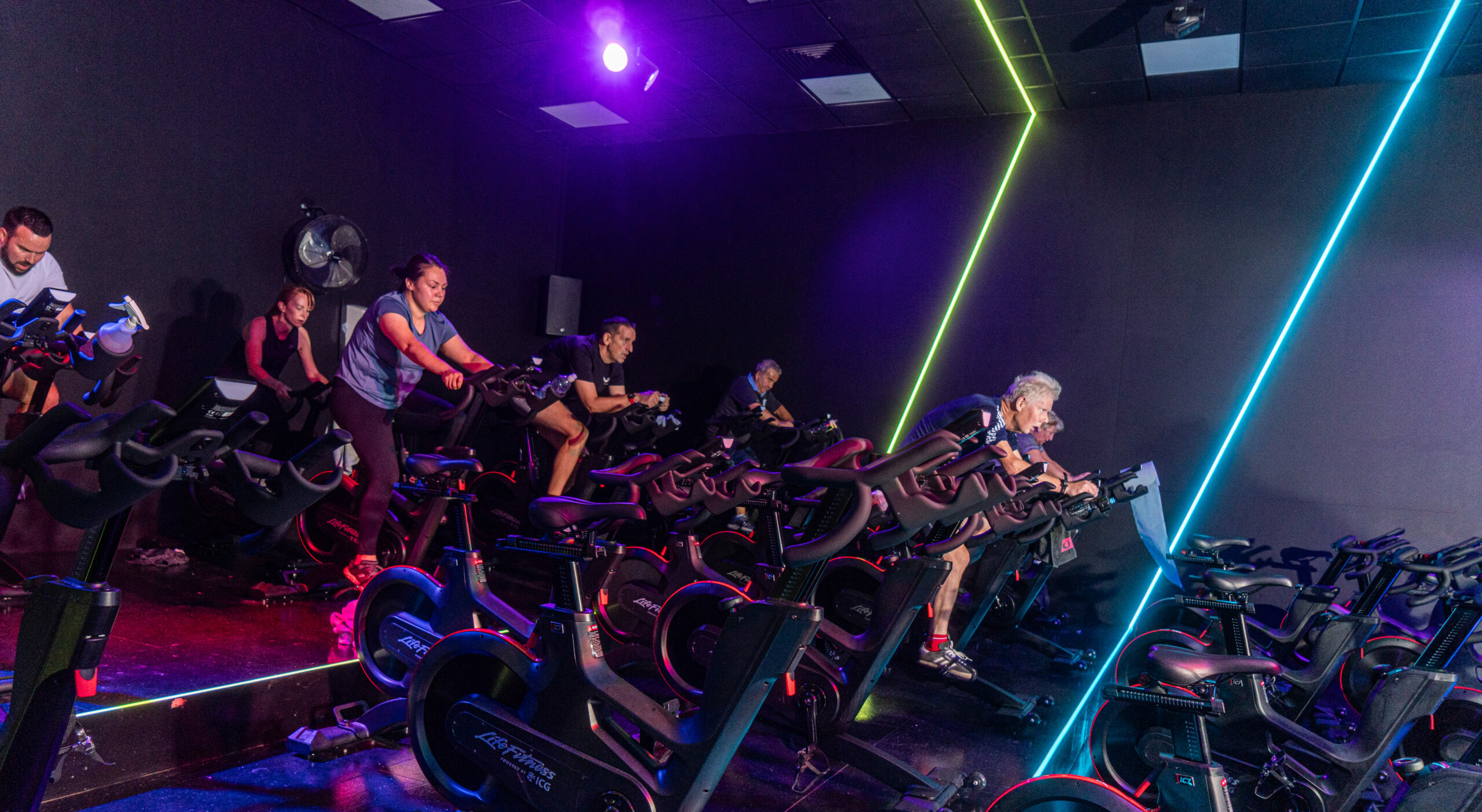 spin class in dark room with neon lights