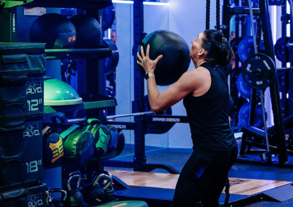 Woman with weighted ball doing wall throws
