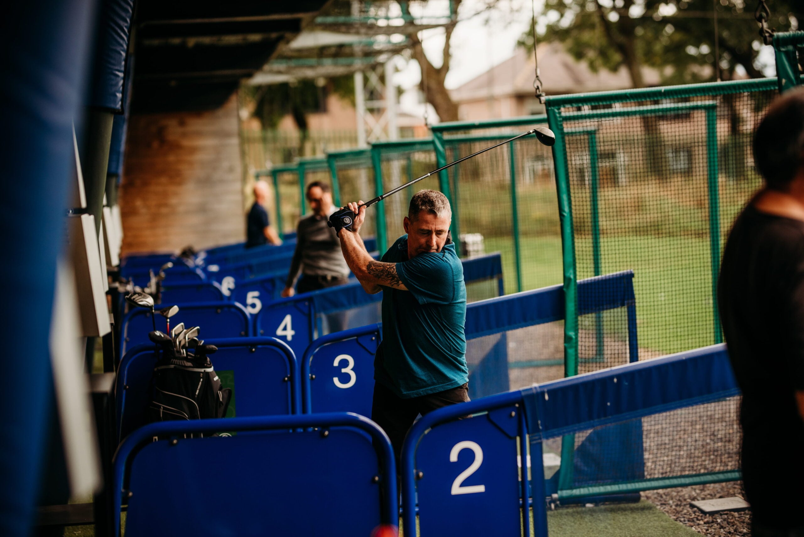 A man adjusts equipment on an outdoor sports court.