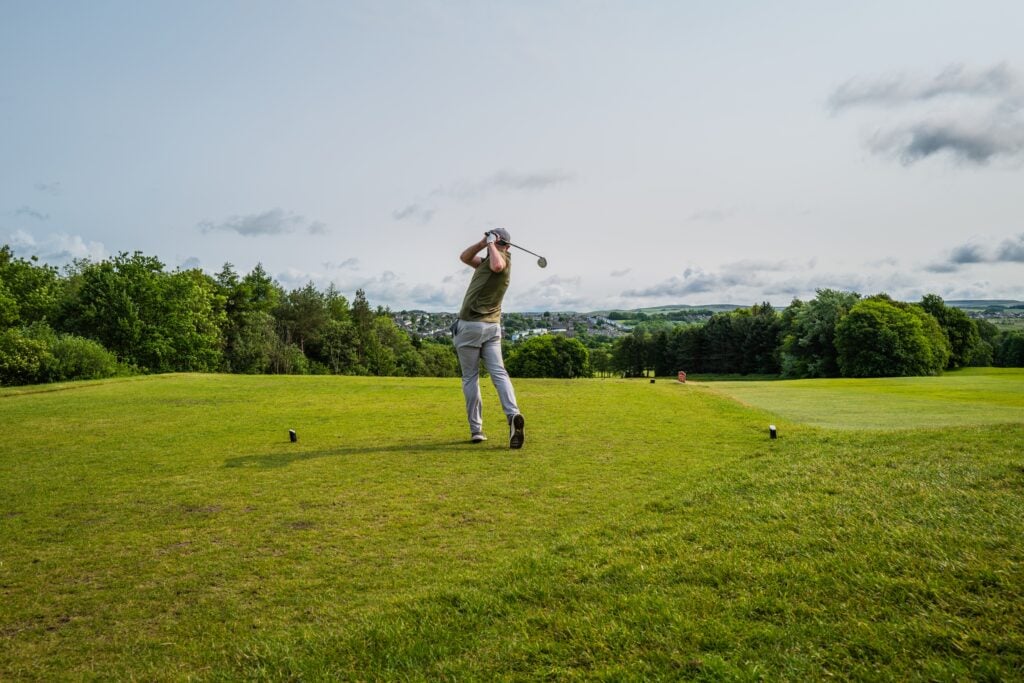 Young man driving the ball down the fairway