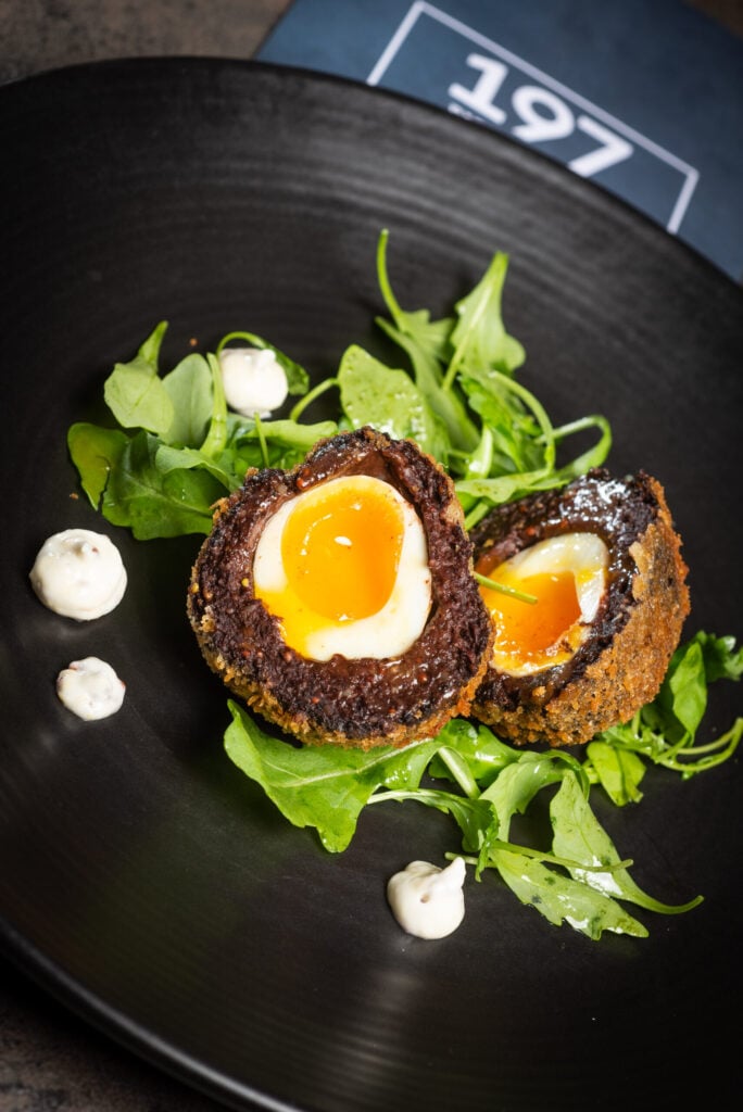 Scot egg on a bed of lettuce