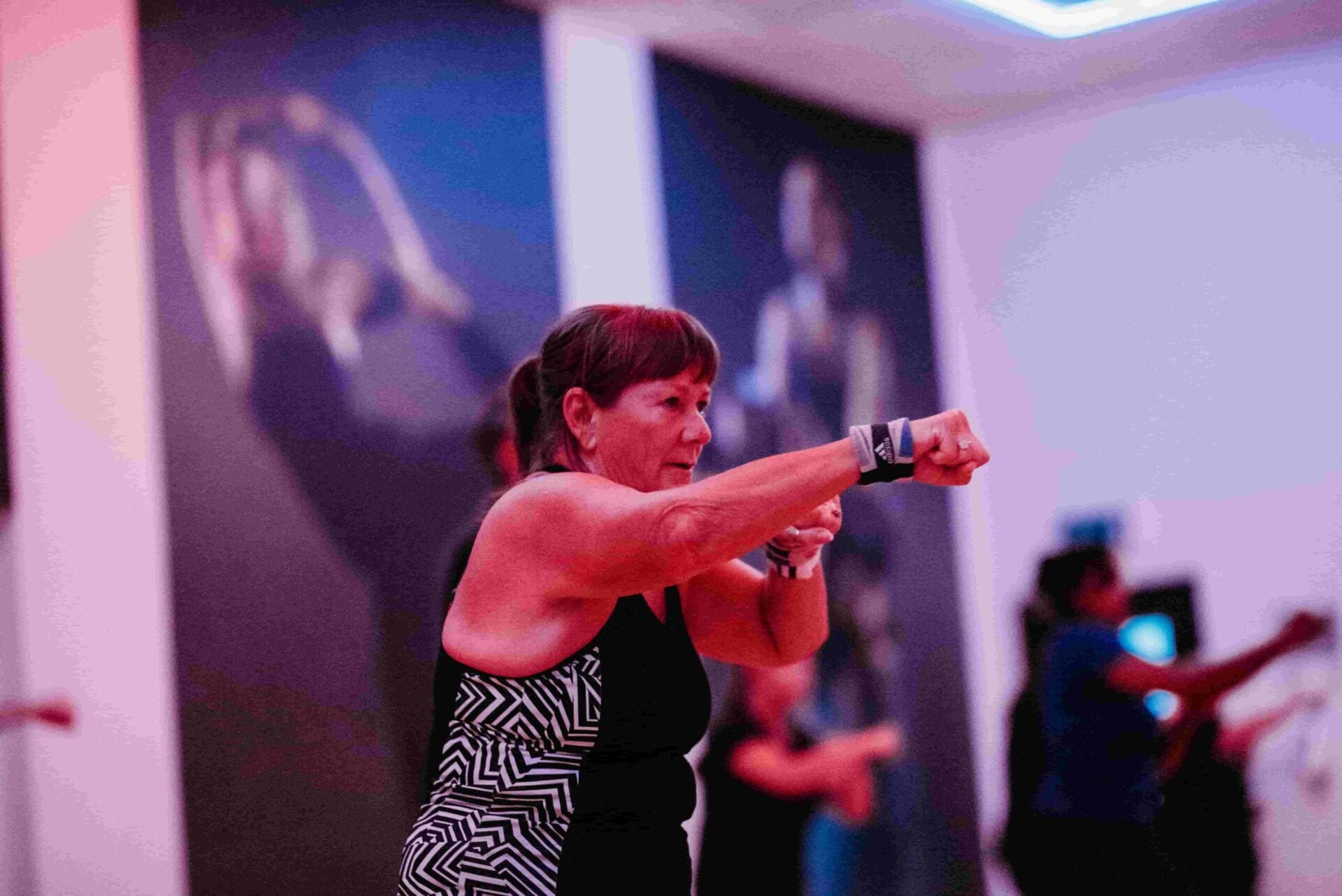 A woman throws a punch during a boxing fitness class.