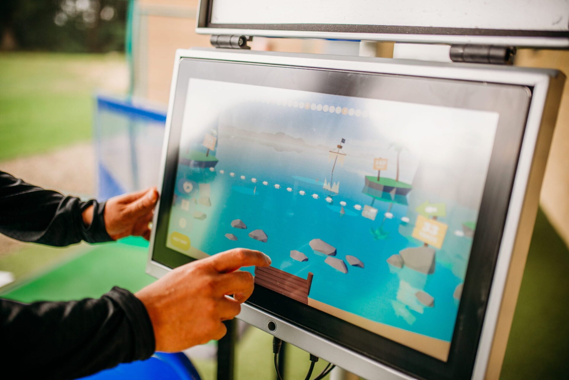 A hand touches an interactive digital display featuring a map and water-themed graphics.