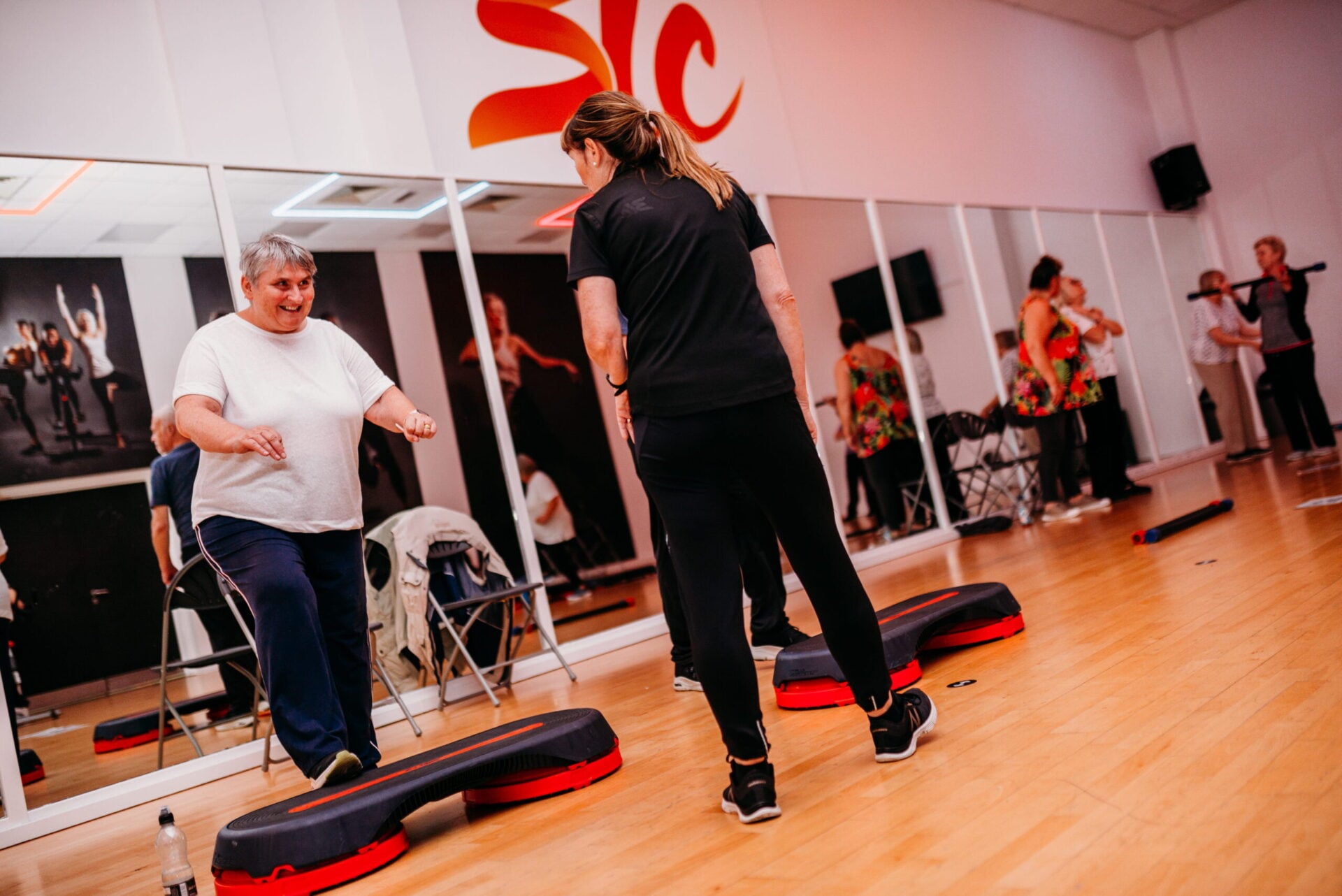 A group fitness class moves through choreographed exercises together.