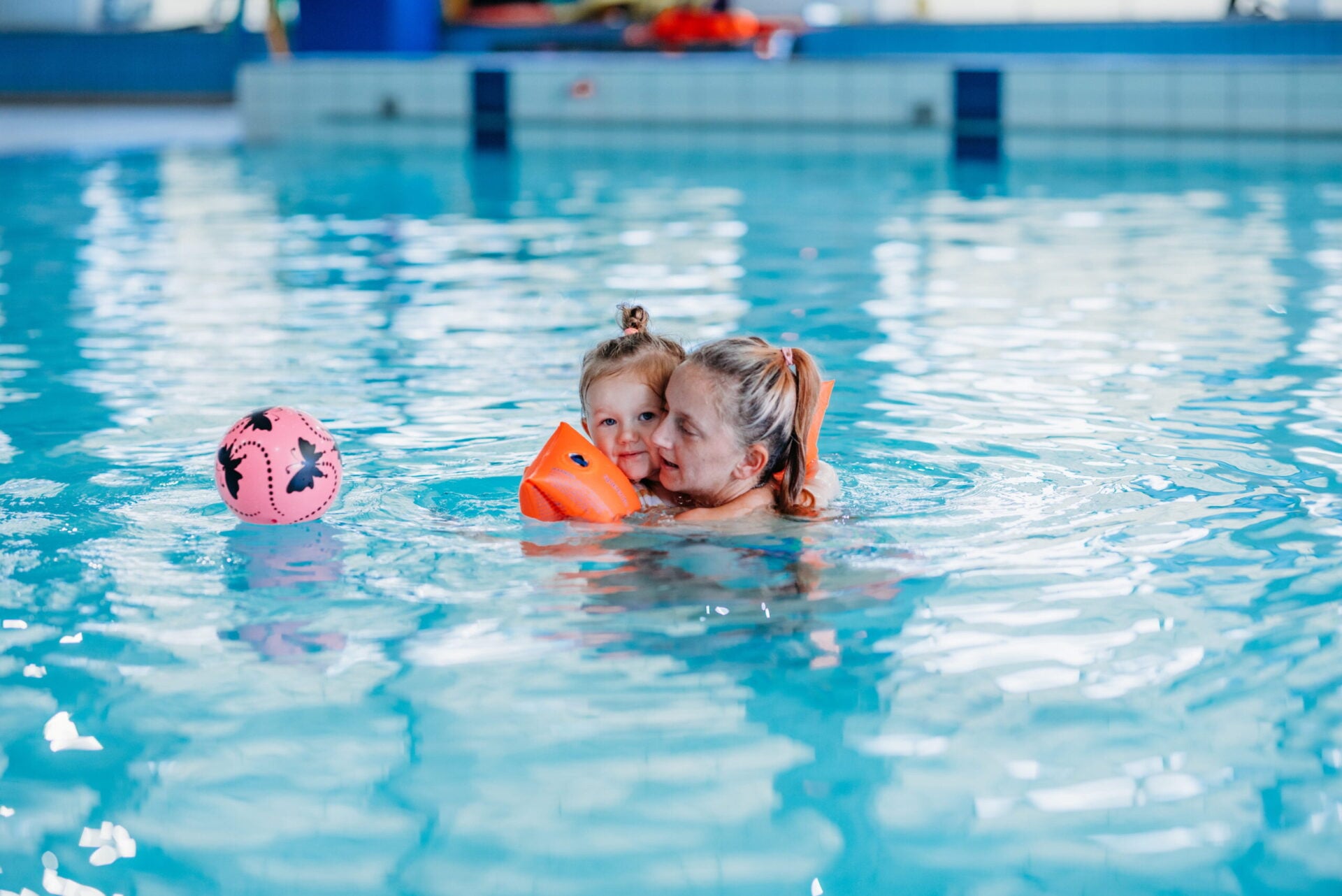 Child in the pool receiving a swimming lesson