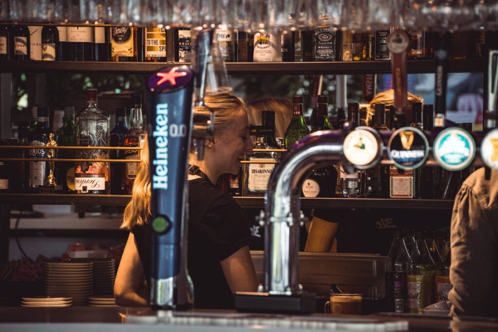 Woman serving drinks behind the bar - Prairie Bistro
