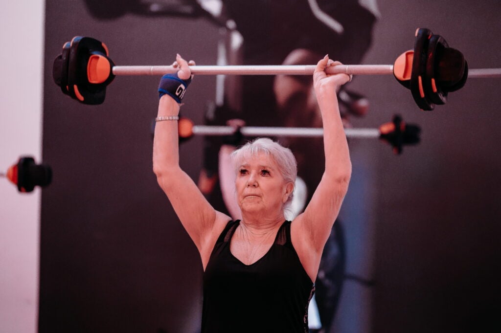 Woman in a gym class lifting weights