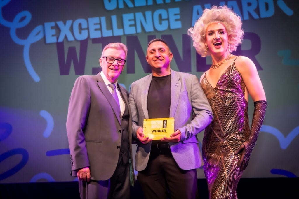 Creative Excellence Award winner Madge Nawaz on stage receiving award