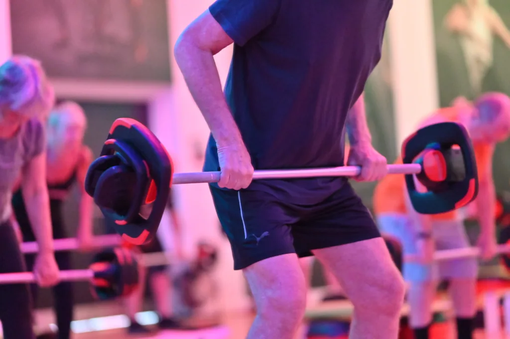 Man lifting a heavy weight in a fitness class