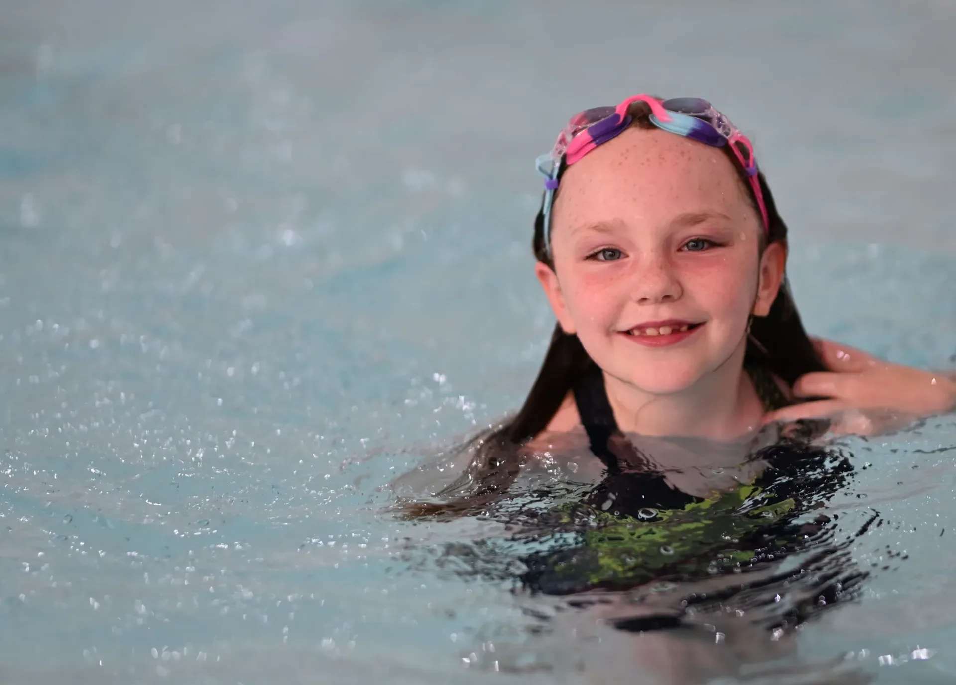 Young girl with goggles on her head smiling