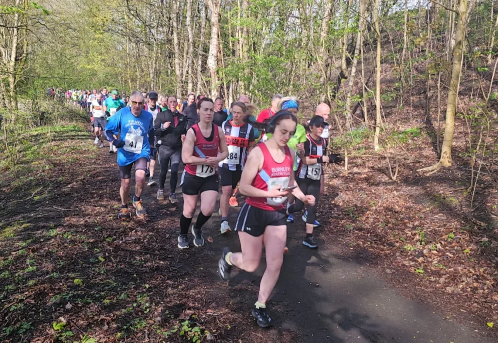 running race on a forest path. Large group running towards the camera